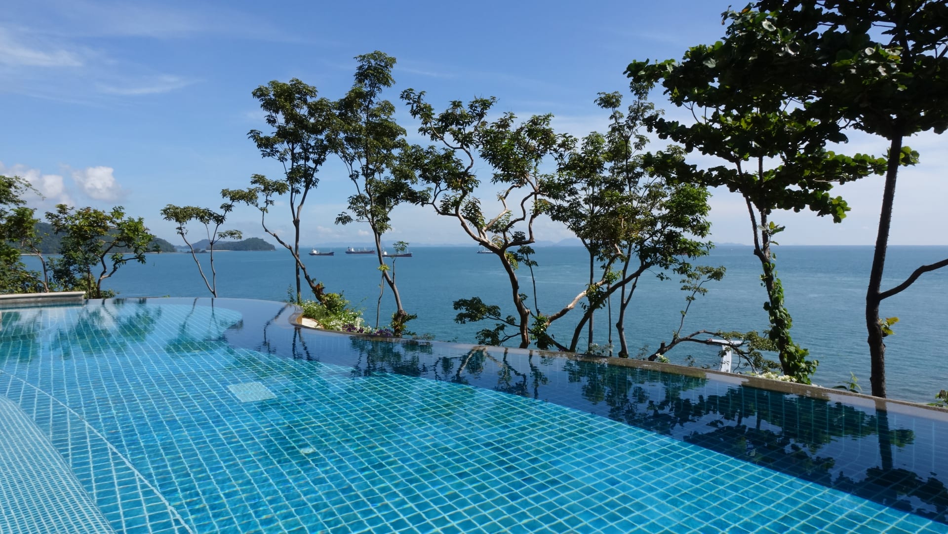 Aerial view of Cape Panwa — the southeastern tip of Phuket where the suite sits, with sheltered bays opening east into the Andaman