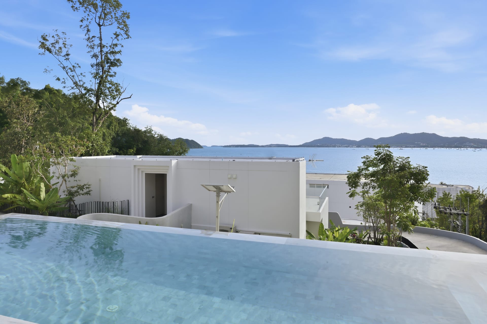 The infinity edge dropping toward the Andaman Sea on a sunny day, the bay and distant islands beyond