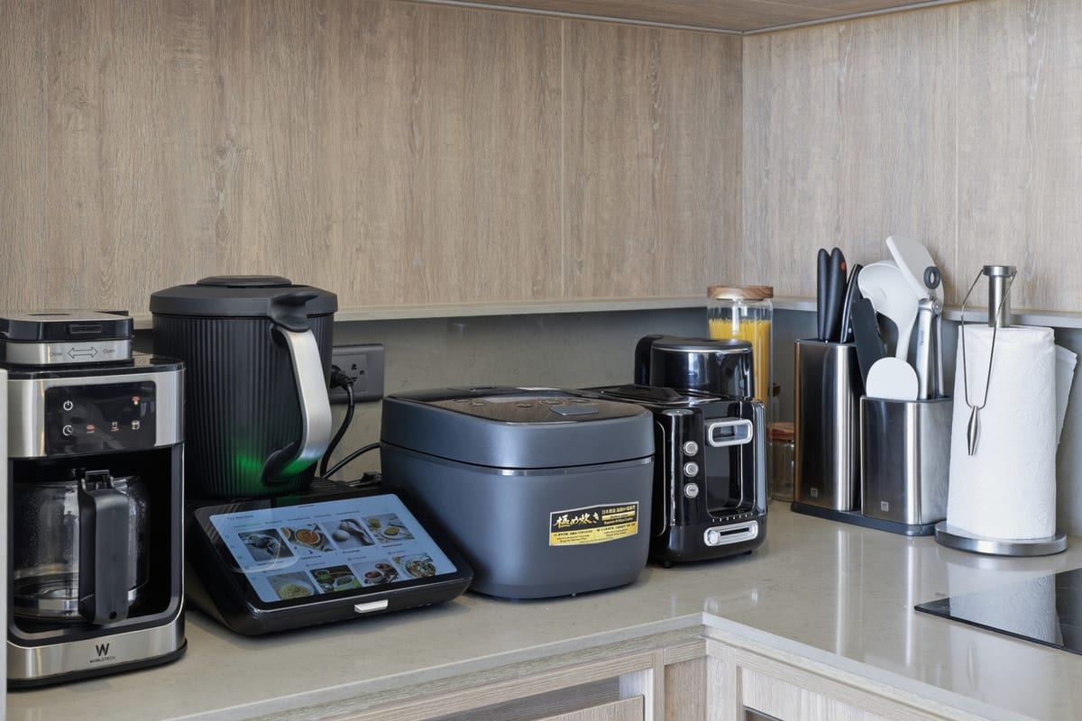 The kitchen counter with coffee maker, kettle, rice cooker and Thermomix, induction hob and full appliances