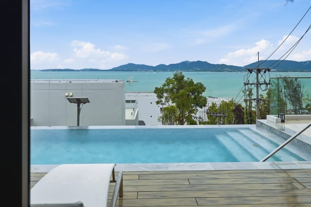 Infinity pool at twilight with pink and orange sky over the Andaman