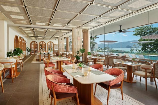 Veranda Resort restaurant interior dining room — woven ceiling, arched walls, sea-facing windows